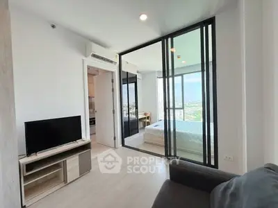 Modern apartment with glass partition, cozy living area, and scenic city view.