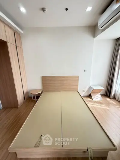 Modern minimalist bedroom with wooden flooring and built-in wardrobe
