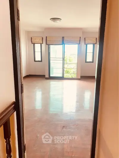 Spacious empty room with large windows and balcony access