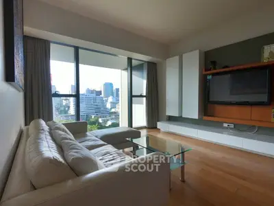Modern living room with city view, featuring sleek furniture and large windows for natural light.