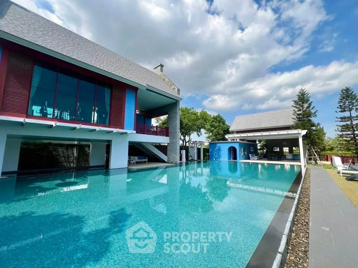 Luxurious modern villa with stunning outdoor pool and spacious terrace under a clear blue sky.