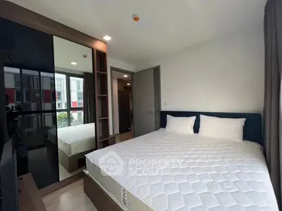 Modern bedroom with large mirror and comfortable bed in stylish apartment