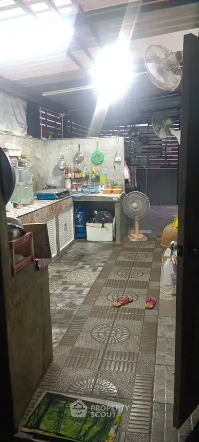 Charming rustic kitchen with unique tile flooring and open layout, featuring ceiling fans and ample storage space.