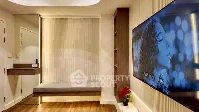 Modern living room with sleek design and large wall-mounted TV, featuring elegant wood flooring.