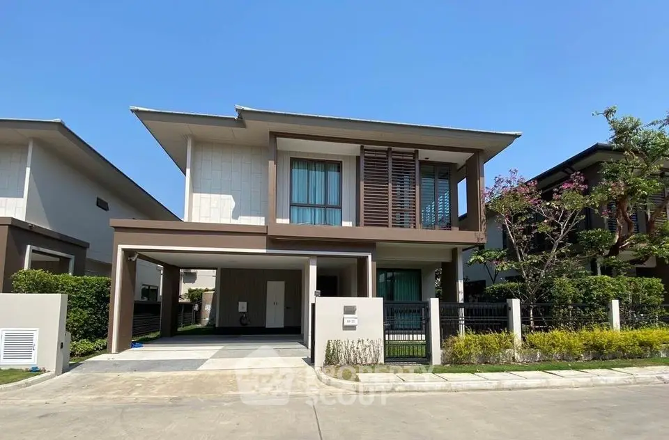 Modern two-story house with sleek design and spacious driveway in a serene neighborhood.