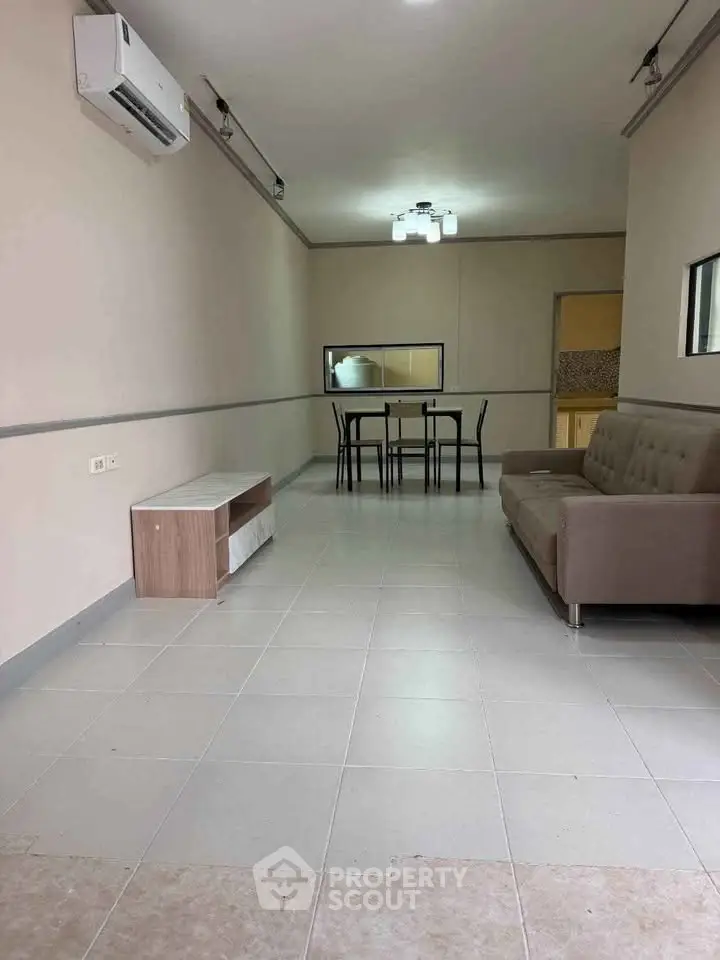 Spacious living room with modern furniture and air conditioning, ideal for comfortable living.