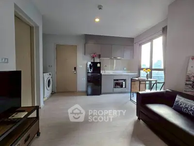 Modern living room with open kitchen and city view, featuring sleek appliances and cozy seating area.