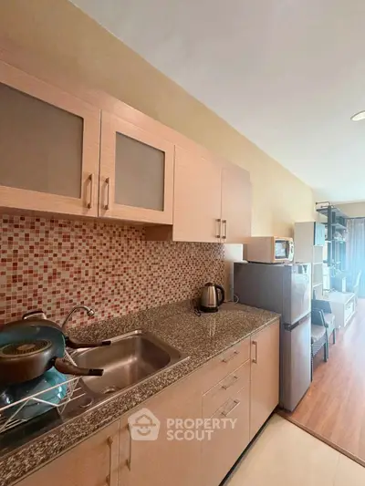 Modern kitchen with granite countertops and mosaic backsplash in cozy apartment
