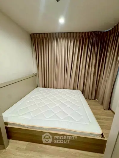 Spacious bedroom with elegant curtains and wooden flooring, perfect for a cozy retreat.
