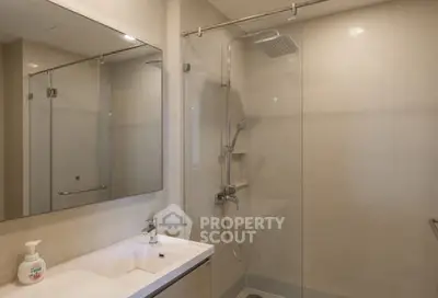 Modern bathroom with glass shower and sleek vanity in a contemporary home.