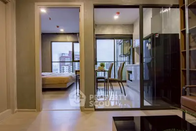 Modern apartment interior with open kitchen and dining area, featuring large windows and stylish decor.
