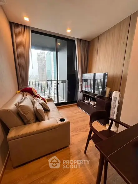 Modern living room with city view, cozy sofa, and sleek TV setup in a high-rise apartment.