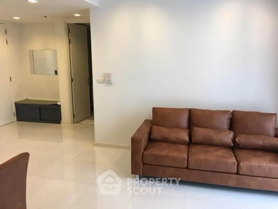 Spacious modern living room with sleek brown leather sofa and minimalist decor