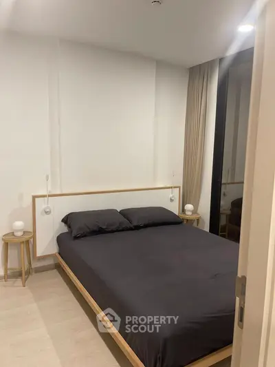 Modern bedroom with minimalist design and cozy ambiance, featuring a comfortable bed and stylish decor.