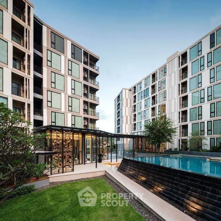 Modern apartment complex with pool and landscaped garden, offering luxurious urban living.