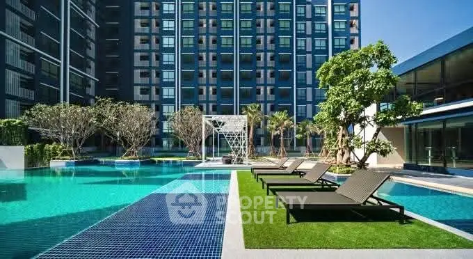 Luxurious modern apartment complex with stunning pool and lush greenery.