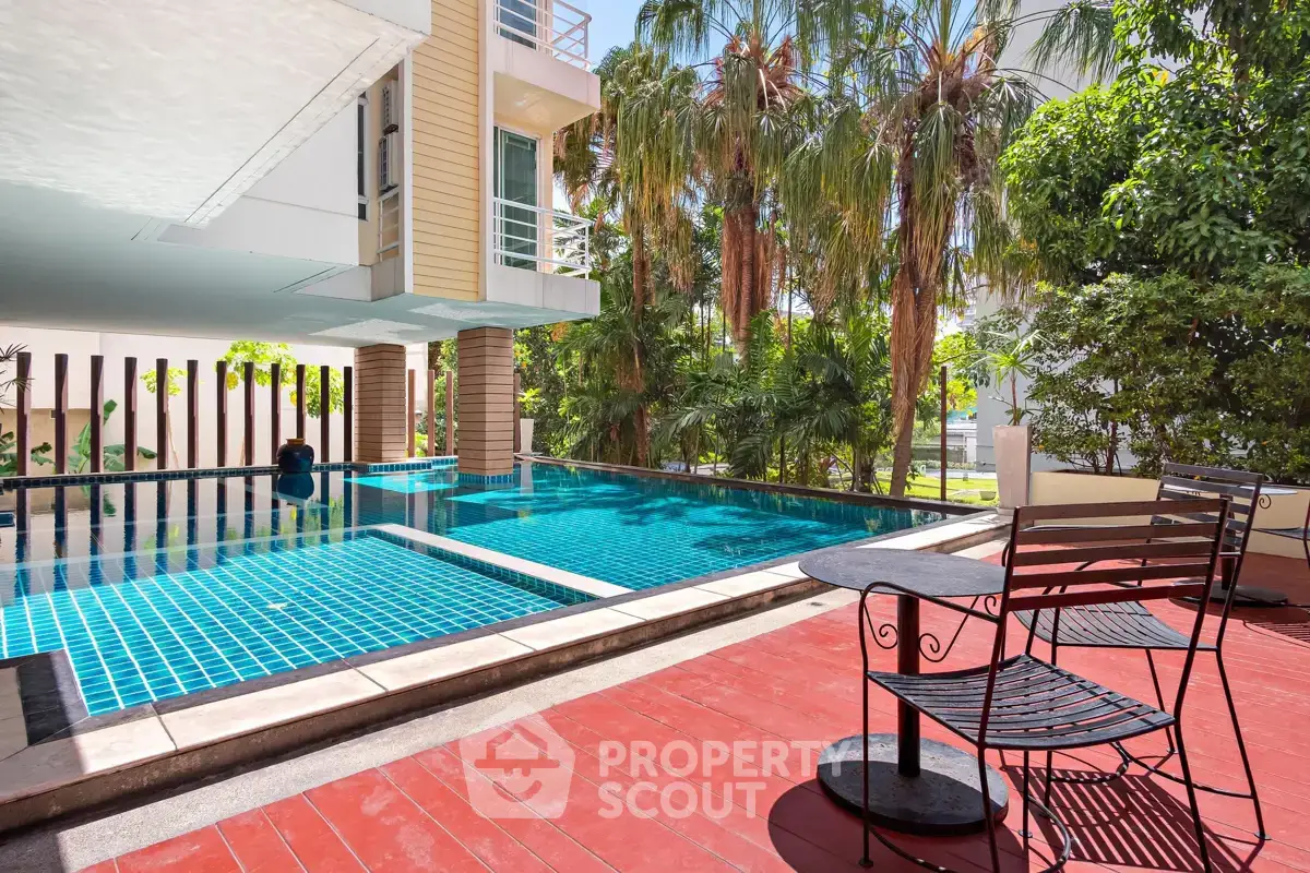 Luxurious poolside area with lush greenery and modern architecture, perfect for relaxation and leisure.