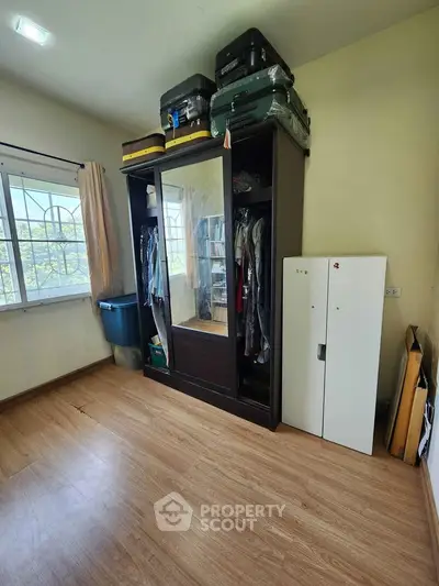 Spacious bedroom with large wardrobe and natural light from window