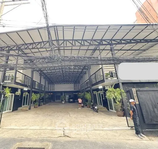 Spacious commercial building with modern industrial design and ample parking space.