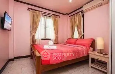 Cozy bedroom with pink walls, wooden bed, and wall-mounted TV