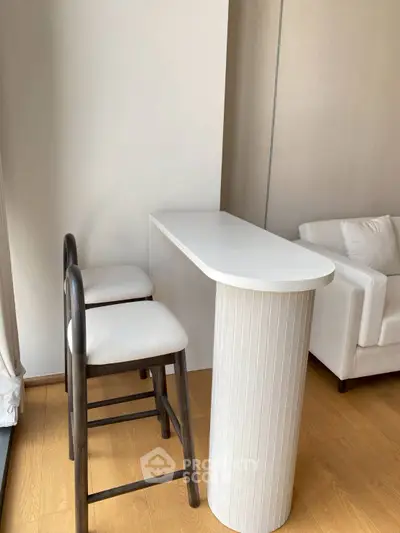 Modern minimalist living room with sleek white furniture and wooden flooring