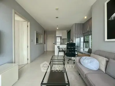 Modern living room with sleek furniture and open layout, featuring a stylish sofa and glass coffee table.