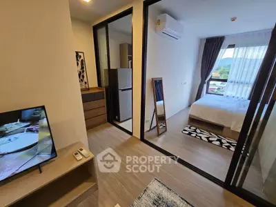 Modern apartment interior with bedroom and living area, featuring sleek design and natural light.