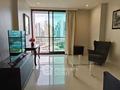 Modern living room with city view, glass coffee table, and elegant armchair
