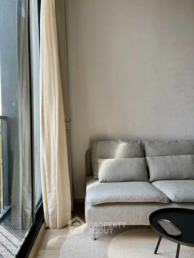 Modern living room with cozy gray sofa and large window for natural light