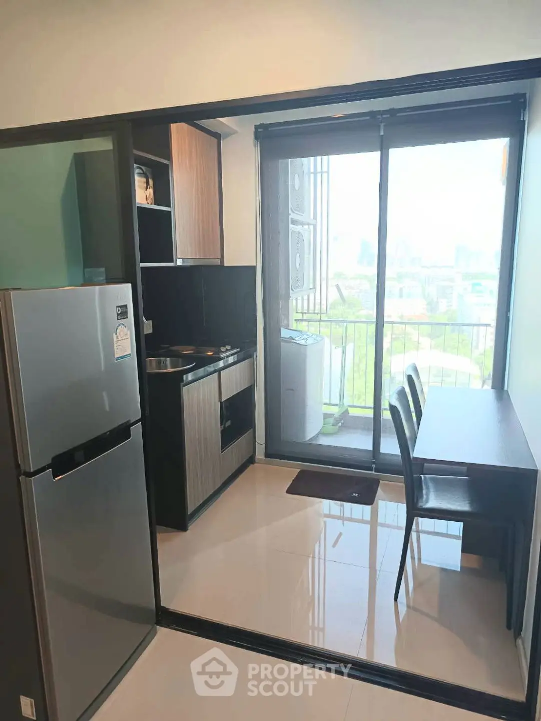 Modern kitchen with sleek appliances and balcony view, perfect for urban living.
