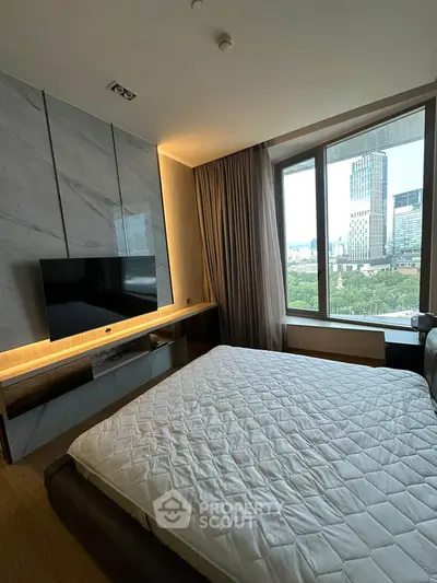 Luxurious bedroom with city view, featuring modern decor and large windows for natural light.
