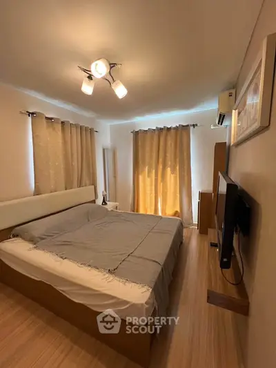 Cozy bedroom with modern lighting and stylish decor, featuring a comfortable bed and elegant curtains.