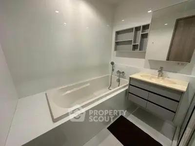 Modern bathroom with sleek bathtub and stylish vanity in a contemporary home.