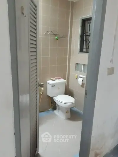 Compact bathroom with tiled walls and standard fixtures