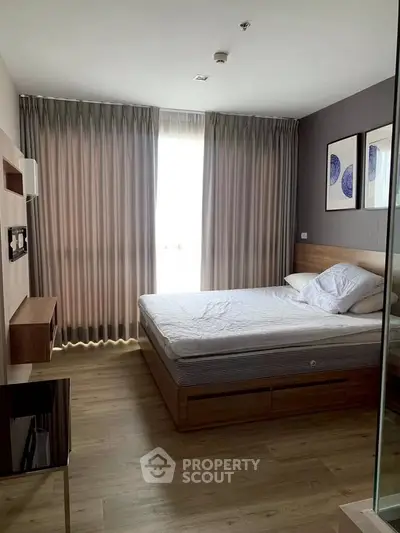 Spacious bedroom with modern decor and large window for natural light