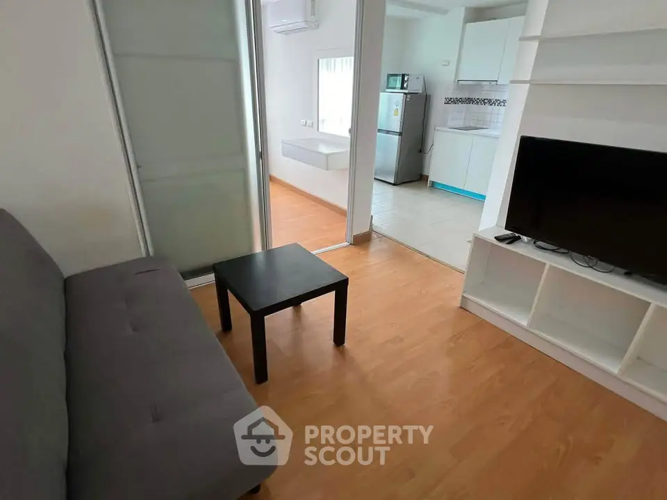 Modern living room with sleek furniture and open kitchen layout, perfect for urban living.