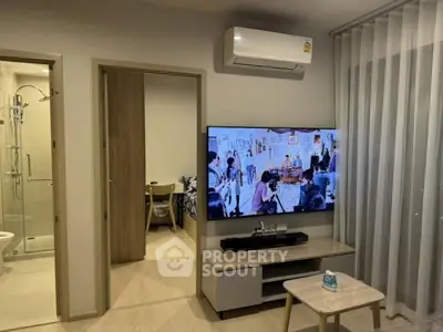 Modern living room with air conditioning and TV, adjacent to bathroom and bedroom.
