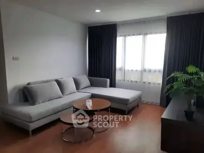 Modern living room with stylish gray sectional sofa and chic coffee table.