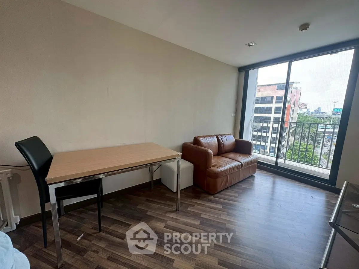 Modern living room with city view, featuring sleek furniture and large windows for natural light.