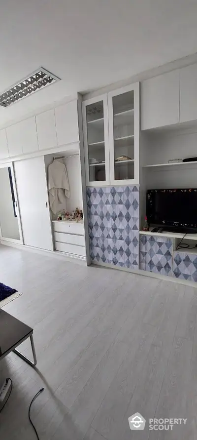 Sleek modern kitchen with stylish blue patterned backsplash, ample white cabinetry, and integrated oven, perfect for culinary enthusiasts.