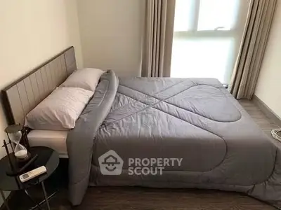 Cozy bedroom with modern decor and natural light, perfect for relaxation.