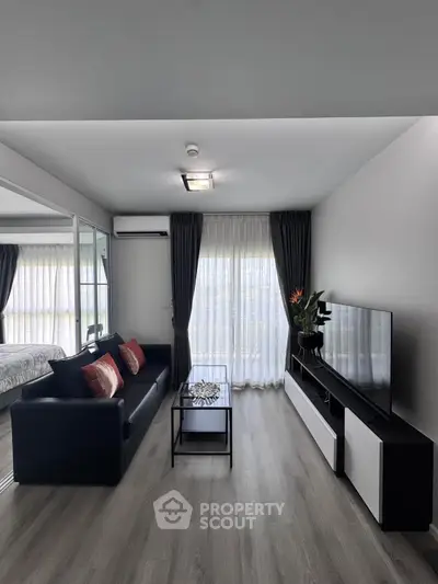 Modern living room with sleek design, large window, and stylish furniture in a contemporary apartment.