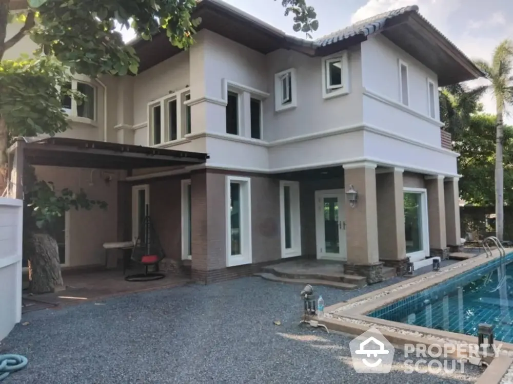 Stunning two-story house with pool and lush greenery, perfect for luxury living.