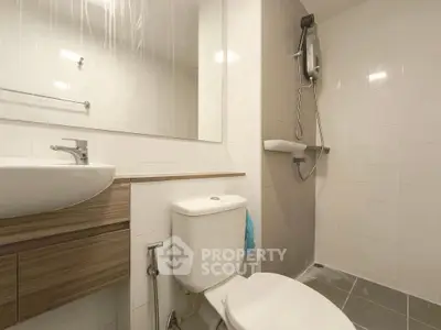 Modern bathroom with sleek fixtures and wall-mounted shower in a minimalist design.