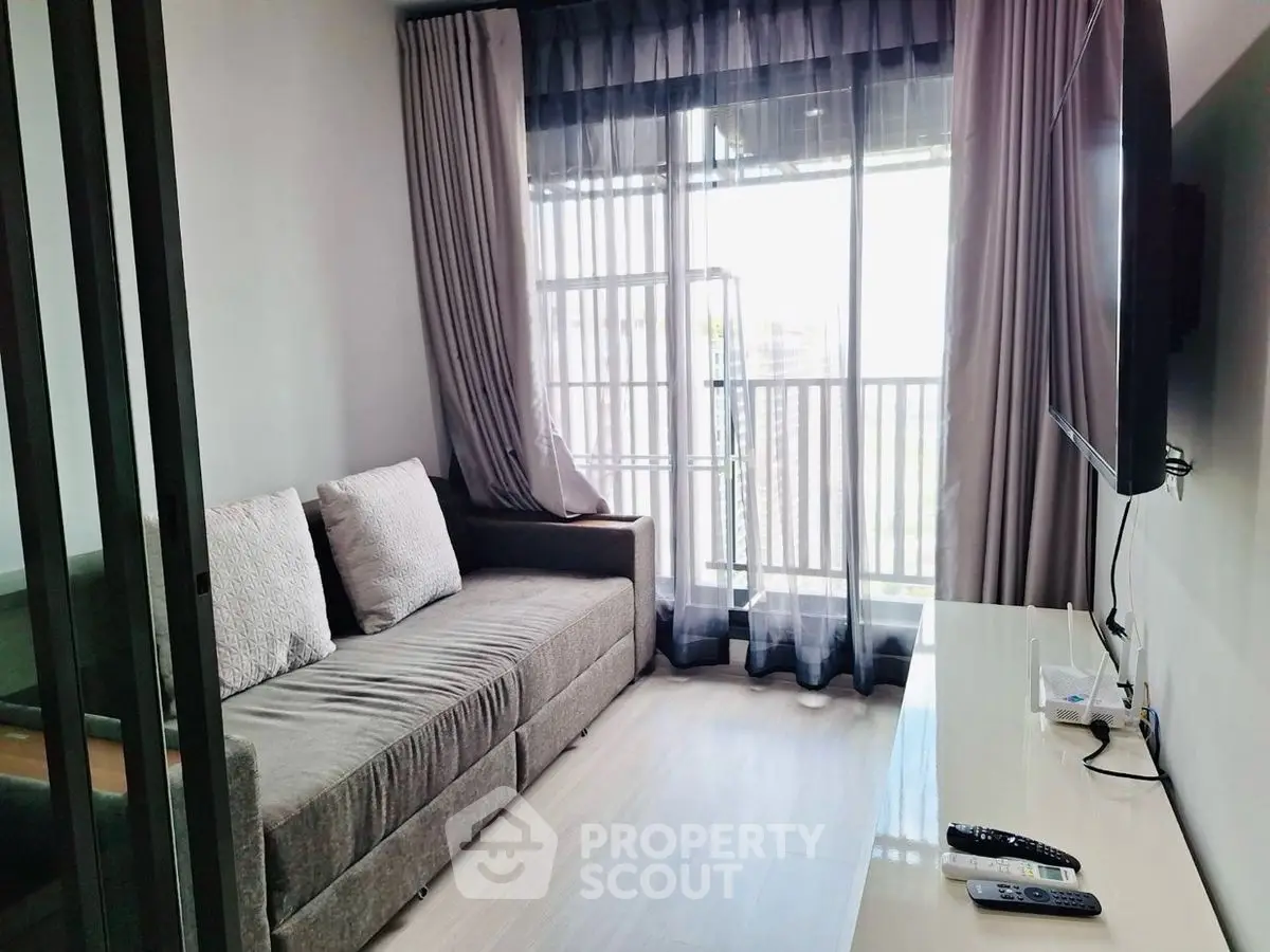 Modern living room with cozy sofa and large window offering natural light.