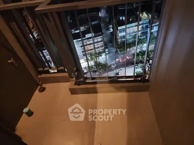 Urban balcony with city view at night, offering a serene escape above the bustling streets.