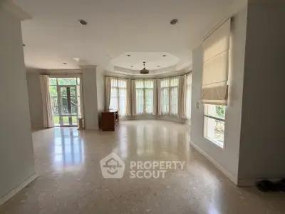 Spacious living room with large windows and natural light, perfect for family gatherings.