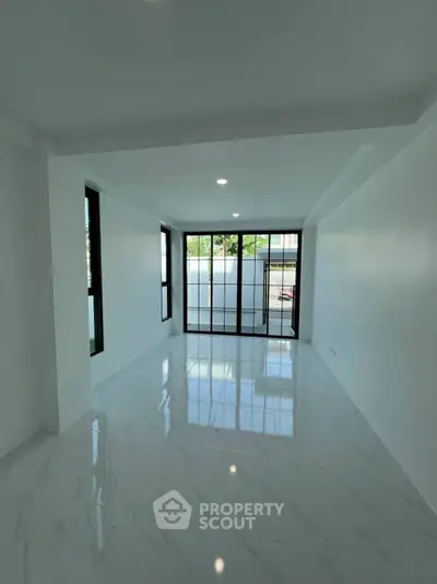 Spacious modern living room with large windows and glossy marble flooring