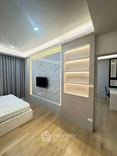 Modern bedroom with built-in TV and illuminated shelves