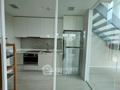 Modern kitchen with sleek cabinetry and stainless steel appliances in a bright, open space.